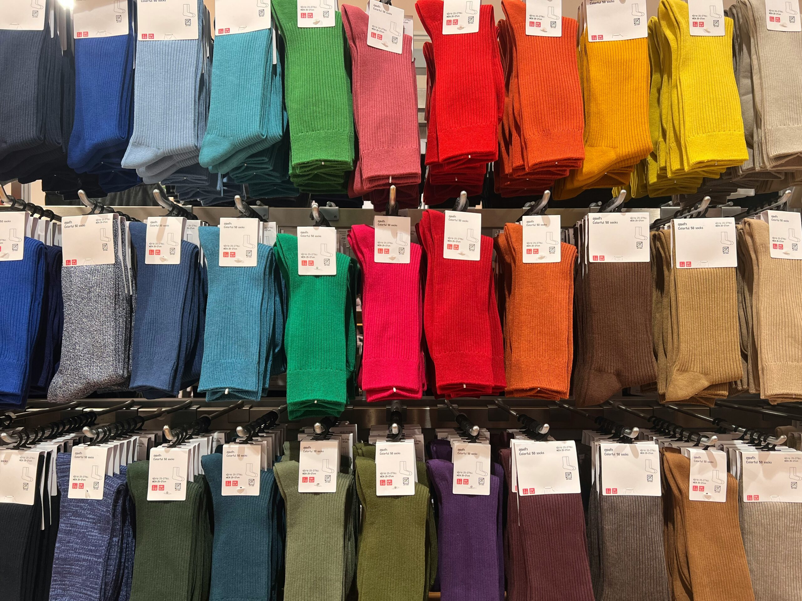 Colorful socks at a Uniqlo store, showcasing the brand's blend of Japanese minimalism and universal appeal in fashion.